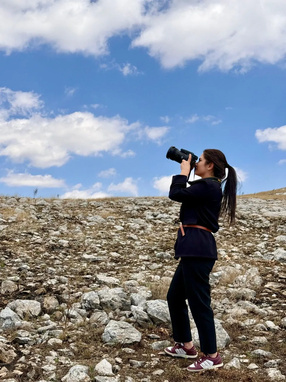Taşlık arazide fotoğraf makinesiyle kuş gözlemi yapan uzman